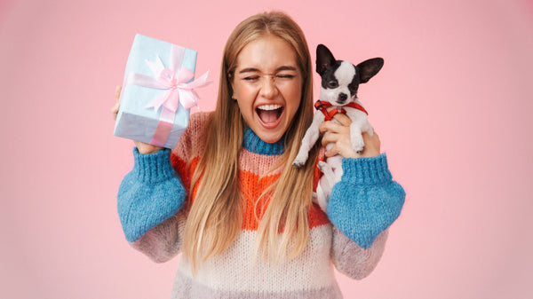 woman holding puppy and gift